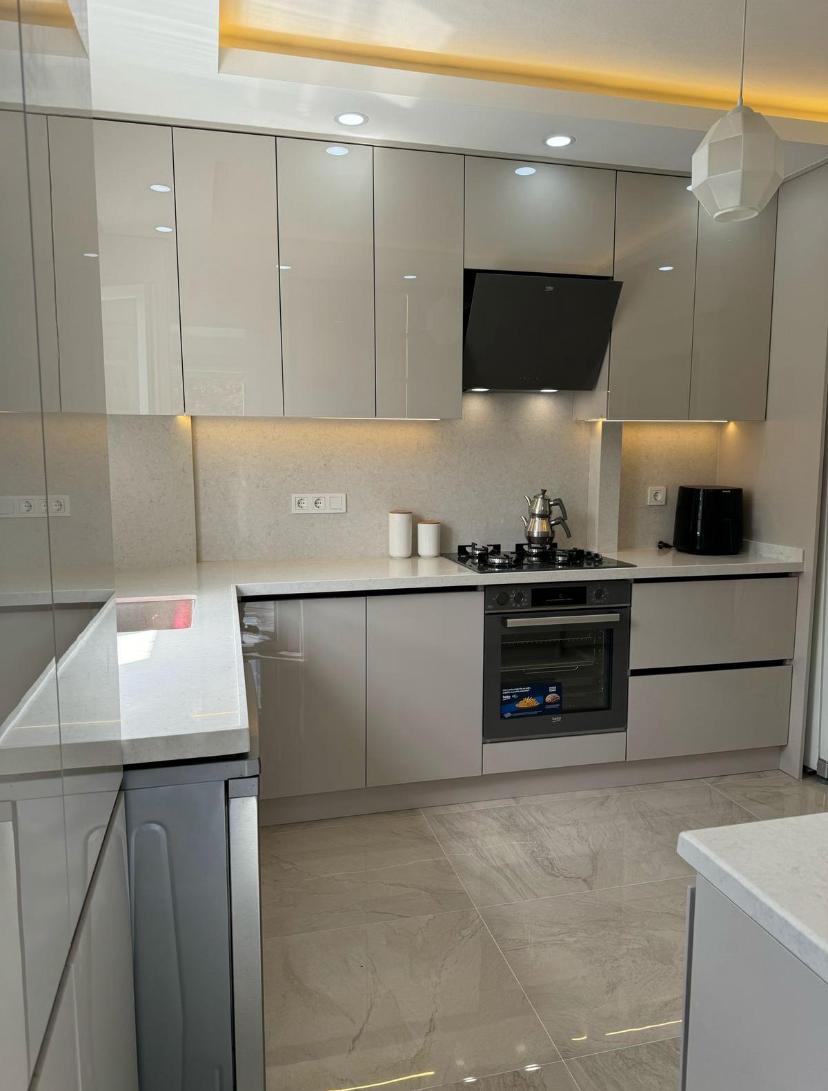 Derin lacivert duvarlar, sıcak ahşap mobilyalar ve zarif fildişi aksanlarla lüks modern oturma odası